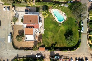 An aerial view of a residential property with a swimming pool, a detached garage, and a large house with a tiled roof. - Villa Matilde Domo Boutique - Suite Pietra di Sale (Torre degli Ulivi)