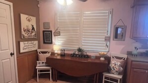 A kitchen with a central island, white cabinets, a ceiling fan, and a window with blinds. - Cute and cozy 3 bedroom 2 bath home. Close to TTU and LCU as well! (Lubbock)