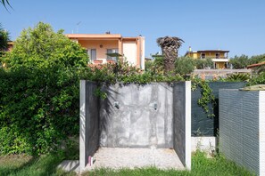 Ein Betongebäude mit Fliesenboden, umgeben von Grünflächen und Gebäuden im Hintergrund.