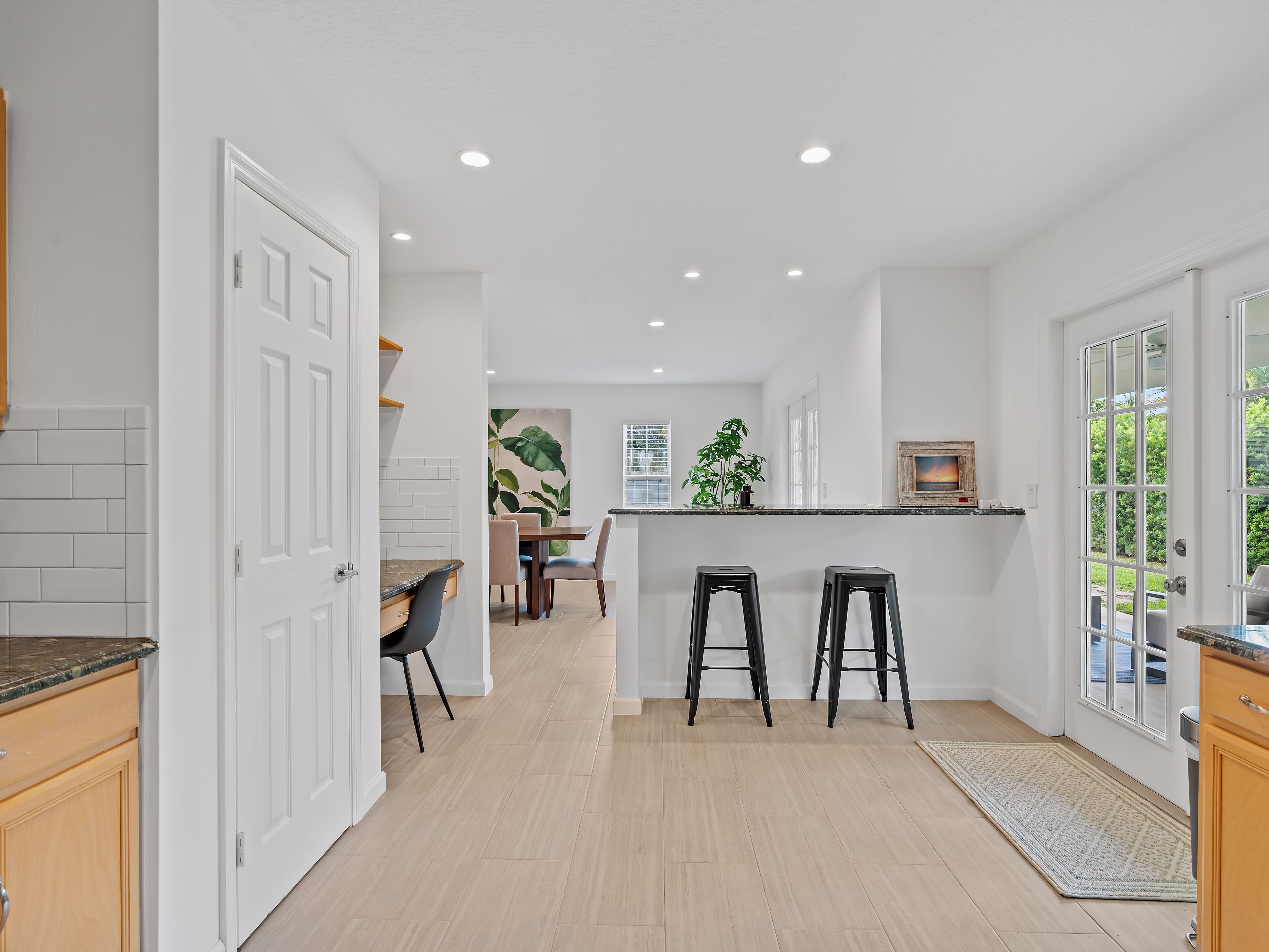 Una cocina moderna con comedor, armarios de madera y vistas al exterior.