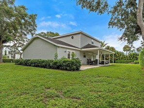 A two-story house with a covered patio and a lawn. - Charming and secluded Jupiter hideaway close to everything!  Pet friendly (Jupiter)