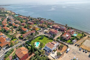 A coastal residential area with houses, a swimming pool, and a beach. - Villa Matilde Domo Boutique – Suite Pietra Daniele (Torre degli Ulivi)