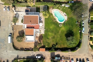 An aerial view of a residential property with a swimming pool, a detached garage, and a large house with a tiled roof. - Villa Matilde Domo Boutique – Suite Pietra Daniele (Torre degli Ulivi)