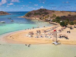 A beach with clear turquoise waters, a sandy shore, and a few boats. - Villa Sunrise Blue – Peaceful Retreat with Bay Views in Cul-de-Sac (Cul-de-Sac)