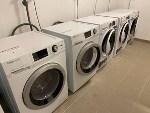 Een rij Haier Hatrim inverter wasmachines in een wasserij.