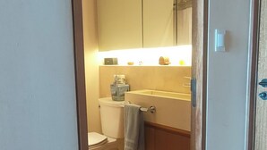 Ein Badezimmer mit Toilette, Waschbecken und Spiegel.