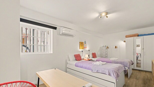 Ein modernes Schlafzimmer mit zwei Betten, einem Schreibtisch und einem Stuhl.