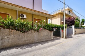 A residential building with a gated entrance, a balcony, and a wall-mounted air conditioning unit. - Attic with Sea View, Wi-Fi and Air Conditioning (Avola)