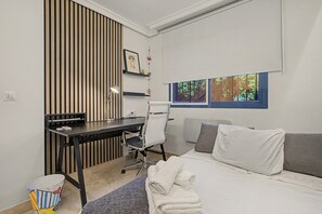 A modern bedroom with a desk, a chair, a bed, and a window with a view of trees. - Apartment 'Casa Soledad' with Sea View, Shared Pool and Wi-Fi (Almuñécar)