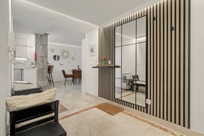 A modern interior with a dining area, a sofa, and a large mirror.