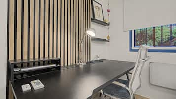 Een moderne kantoorruimte met een bureau, stoel en een groot raam.