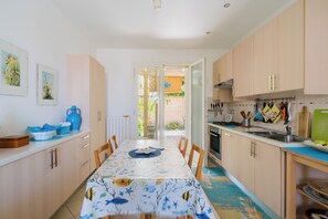Uma cozinha com área de refeições, armários de madeira e vista para o exterior.