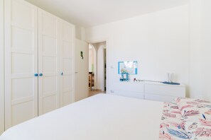 A bedroom with a bed, a wardrobe, a dresser, and a mirror. - Villetta Fico d`India by BarbarHouse (Sant'Isidoro)