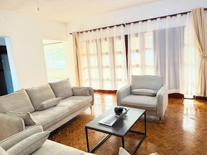 A living room with a sofa, armchair, and coffee table.