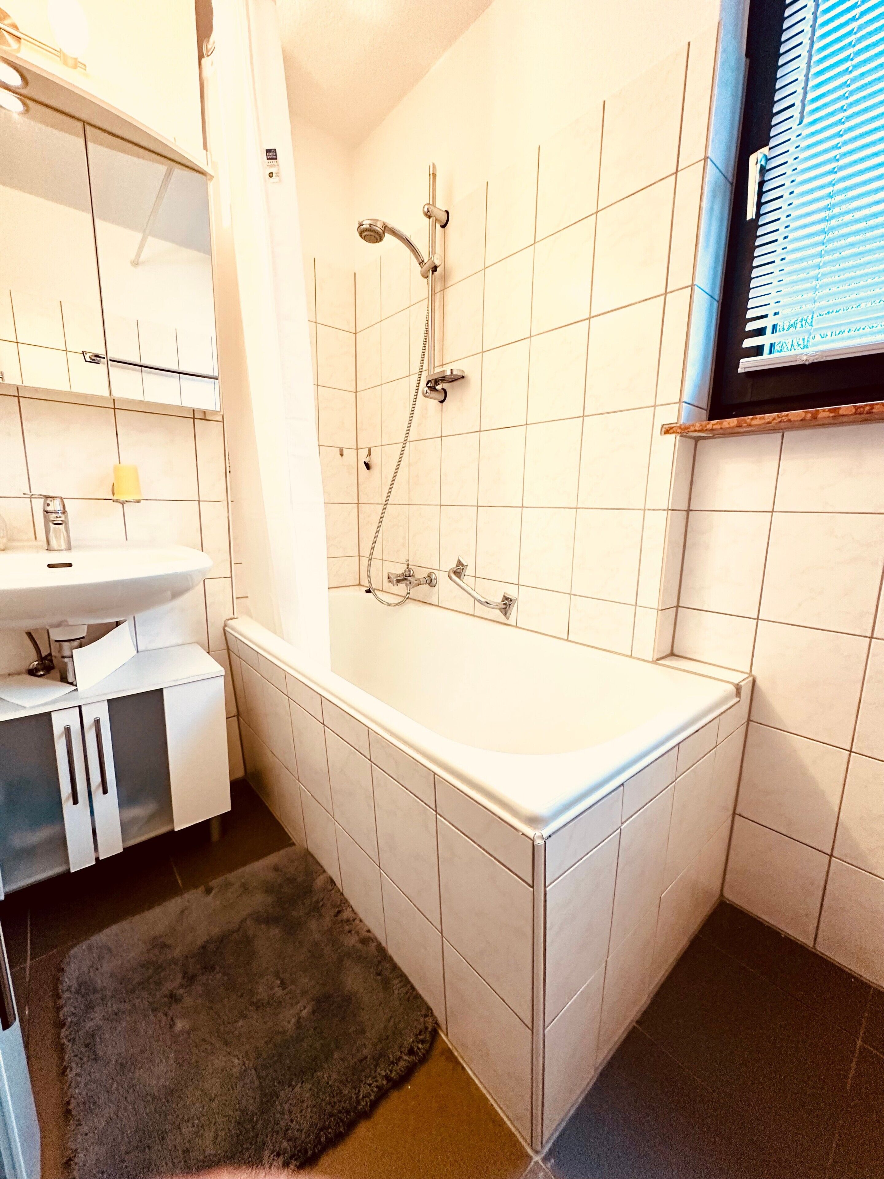 Un baño con bañera, lavamanos y espejo.