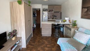 A compact living space with a kitchenette, a dining area, and a sofa. - Bright studio apartment 50 meters from the beach (Mauguio)