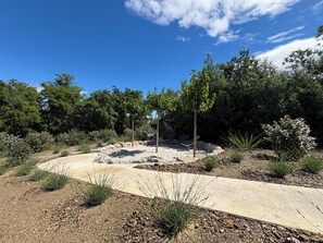 A landscaped garden with a gravel path, seating area, and trees. - Exclusive modern vacation home with spectacular views and beautiful terraces (Maureillas)