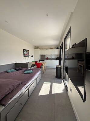 A compact room with a bed, a small dining table, a kitchenette, and a trash bin. - Exclusive modern vacation home with spectacular views and beautiful terraces (Maureillas)