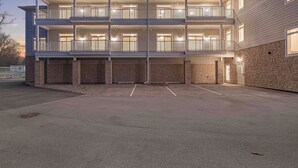 Monikerroksinen rakennus, jossa on parvekkeita, kiviverhous ja pysäköintialue.