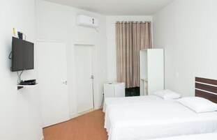 Una habitación de hotel con cama, televisión, armario y puerta.