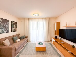 A modern living room with a sofa, coffee table, and a flat-screen TV. - Apartment Praia Rocha | Elite Residence | Prestige (Portimão)