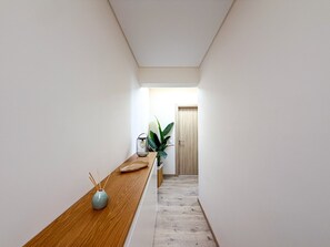 A narrow hallway with a wooden bench, a vase with reed diffusers, and a potted plant. - Apartment Praia Rocha | Sea View | Prestige (Portimão)