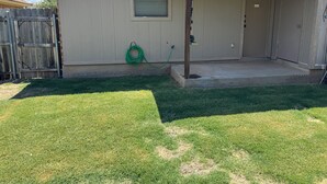 A residential house with a covered porch, a wooden fence, and a green garden hose. - Newly Updated 2BR/2BA • King Suite • Near ACU (Abilene)