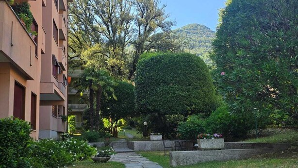 Un camino de piedra que lleva a un edificio de techo plano y varias ventanas.