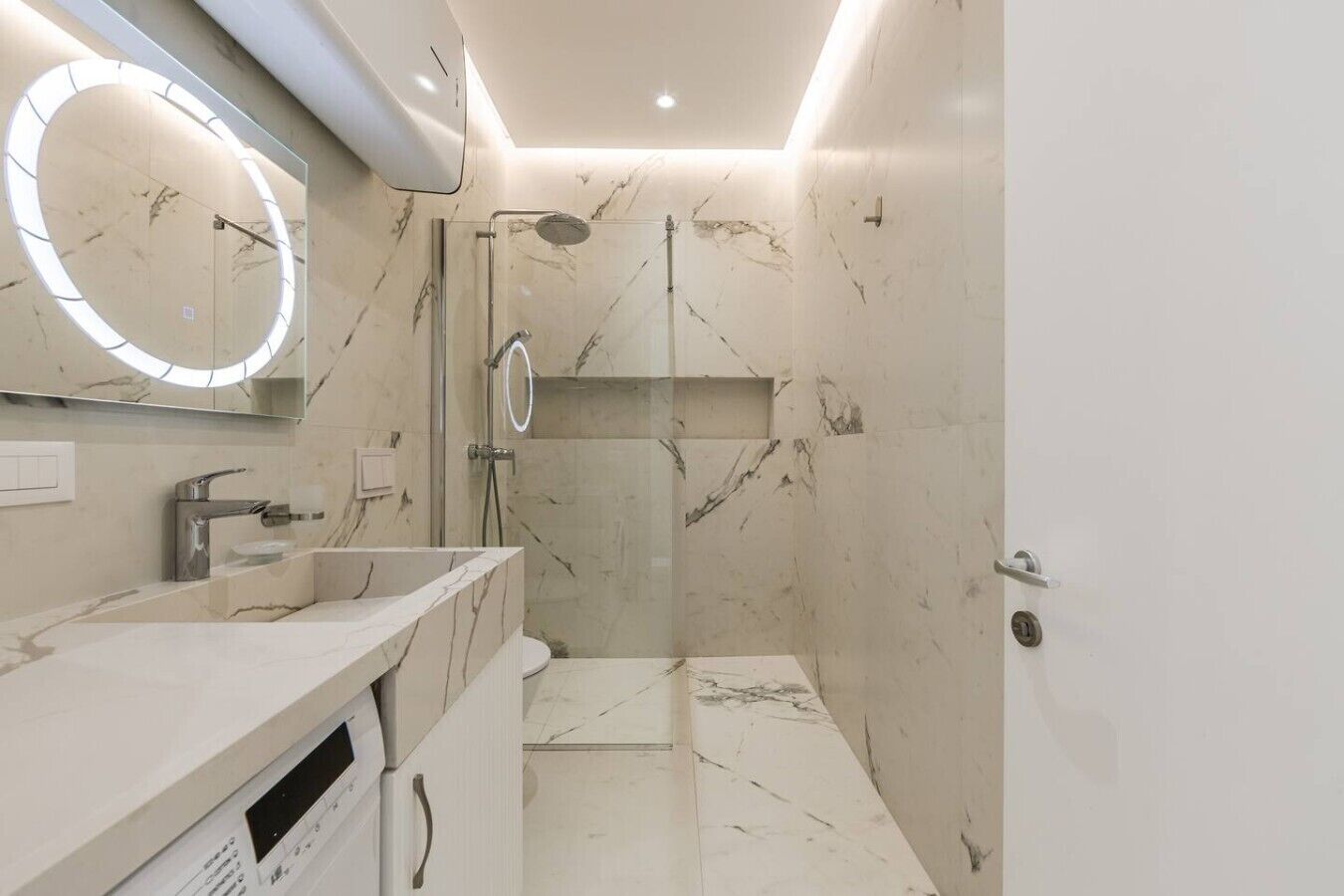 A modern bathroom with a vanity, a shower, and a large mirror.
