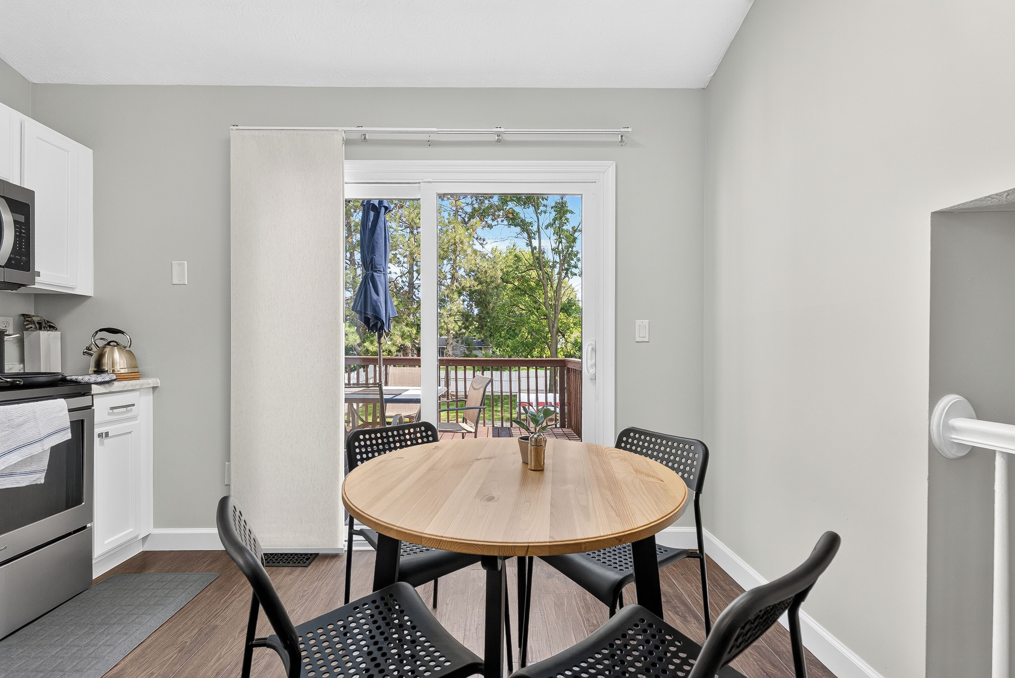 A compact kitchen with a dining area, a sliding glass door leading to an outdoor deck.