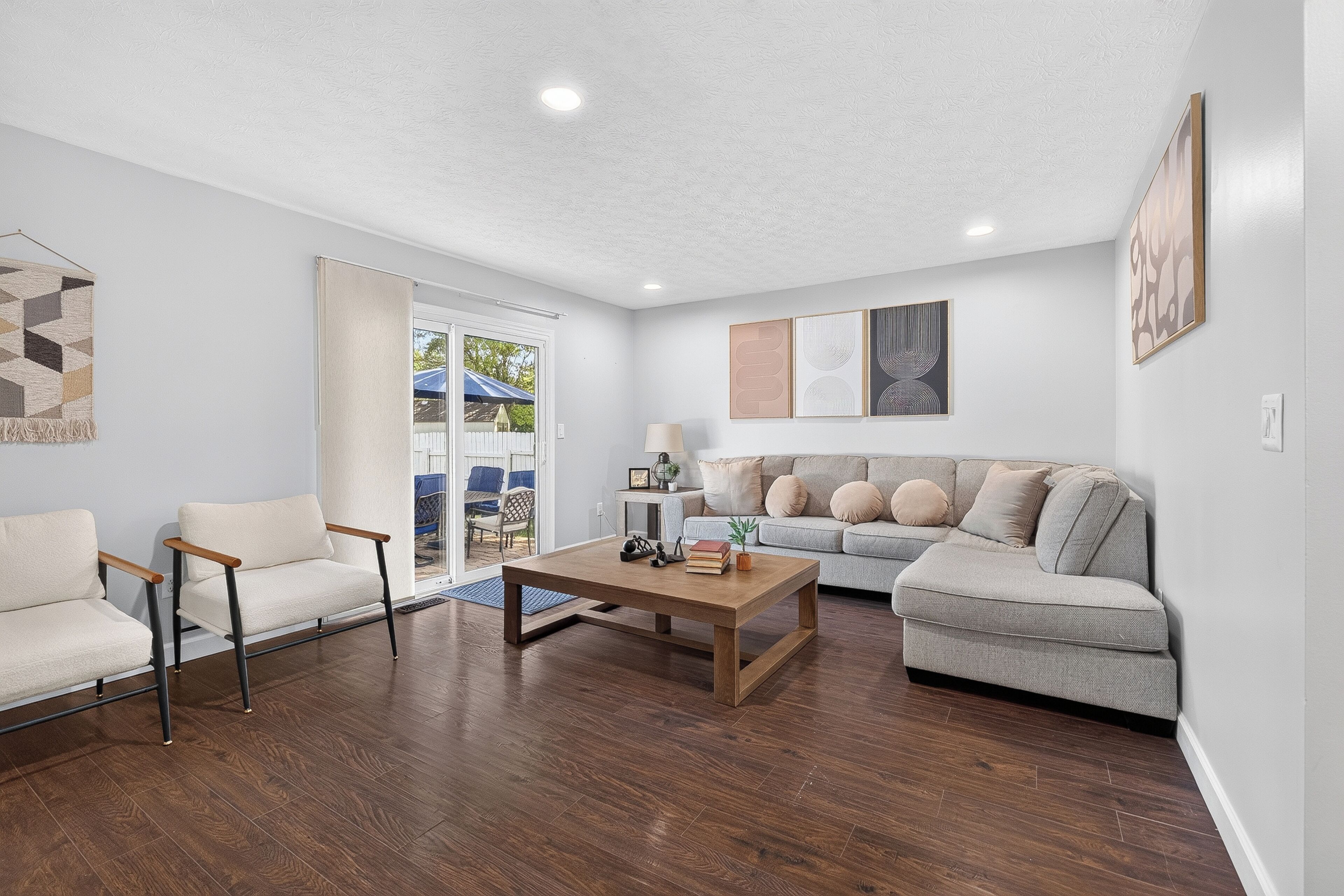 A living room with a sofa, chairs, a coffee table, and artwork on the walls.