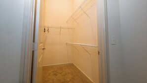 A small, carpeted closet with metal shelving units and a door. - 2-bedroom apartment in beautiful Dallas with AC and fitness room (Dallas)