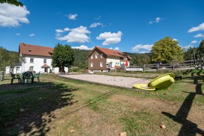 Un quartier résidentiel avec une grande maison, une petite piscine et une cour gazonnée.