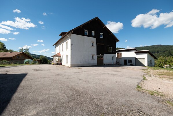 A two-story building with a gravel driveway and a clear sky.