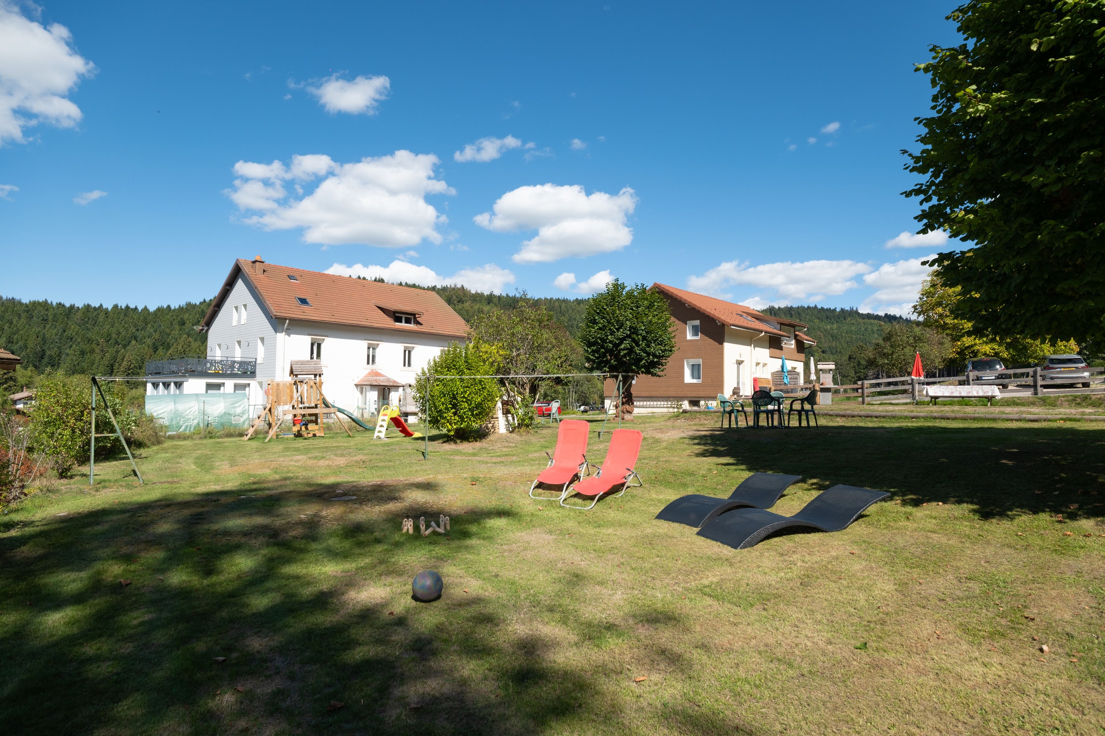 Ein Wohngebiet mit zwei Häusern, einem Rasen und einem Spielplatz.