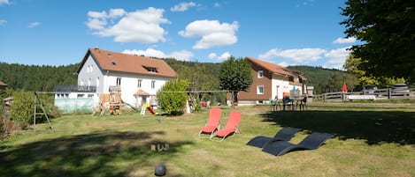A residential area with two houses, a grassy yard, and a playground.