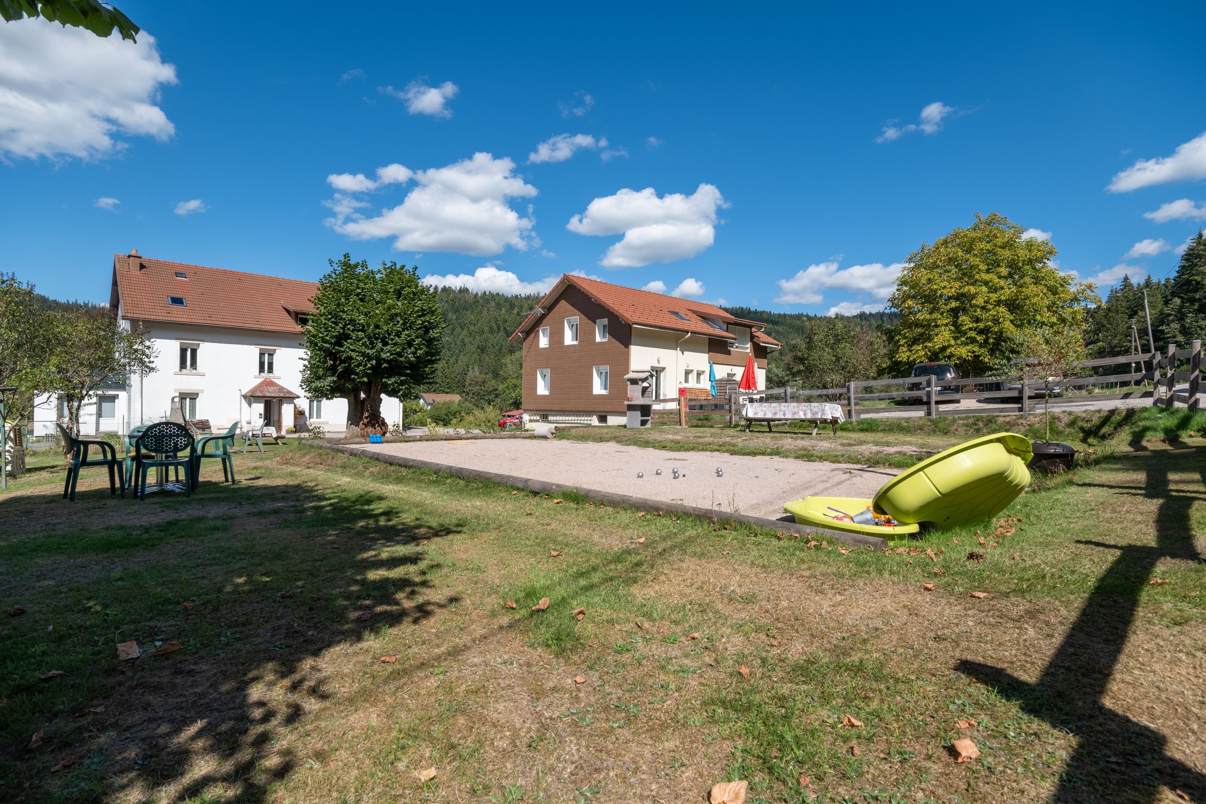 Ein Wohngebiet mit einem Haus, Sitzgelegenheiten im Freien und einem Schwimmbad.