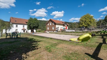 Ein Wohngebiet mit einem Haus, Sitzgelegenheiten im Freien und einem Schwimmbad.