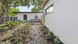Una casa moderna amb una zona de terrassa, un sofà gris i una taula petita.