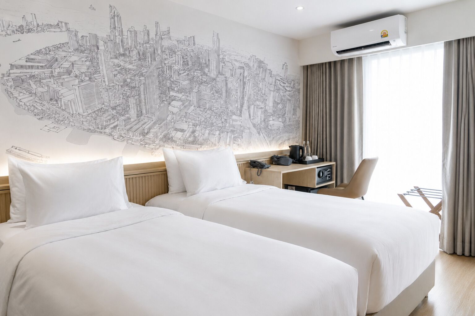 Quarto de hotel com duas camas, um mural de paisagem urbana, um ar condicionado, uma mesa com telefone e uma cadeira.