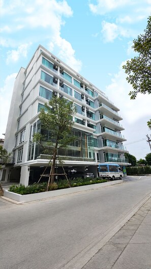 A multi-story building with a modern architectural design, featuring balconies and large windows. - Surestay By Best Western Siriraj Bangkok (Bangkok)