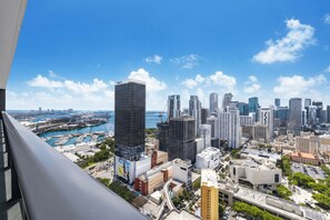 Un paysage urbain avec de hauts immeubles, un port de plaisance et un ciel bleu dégagé.