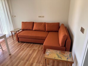 A living room with a sofa, a small table, and a decorative table with a floral design. - Private Pool Modern&Delightful Farmhouse In Nature With AC Near Sea&Airport (Dalaman)