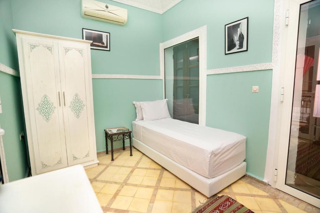 Una habitación con cama, armario, ventana y puerta.