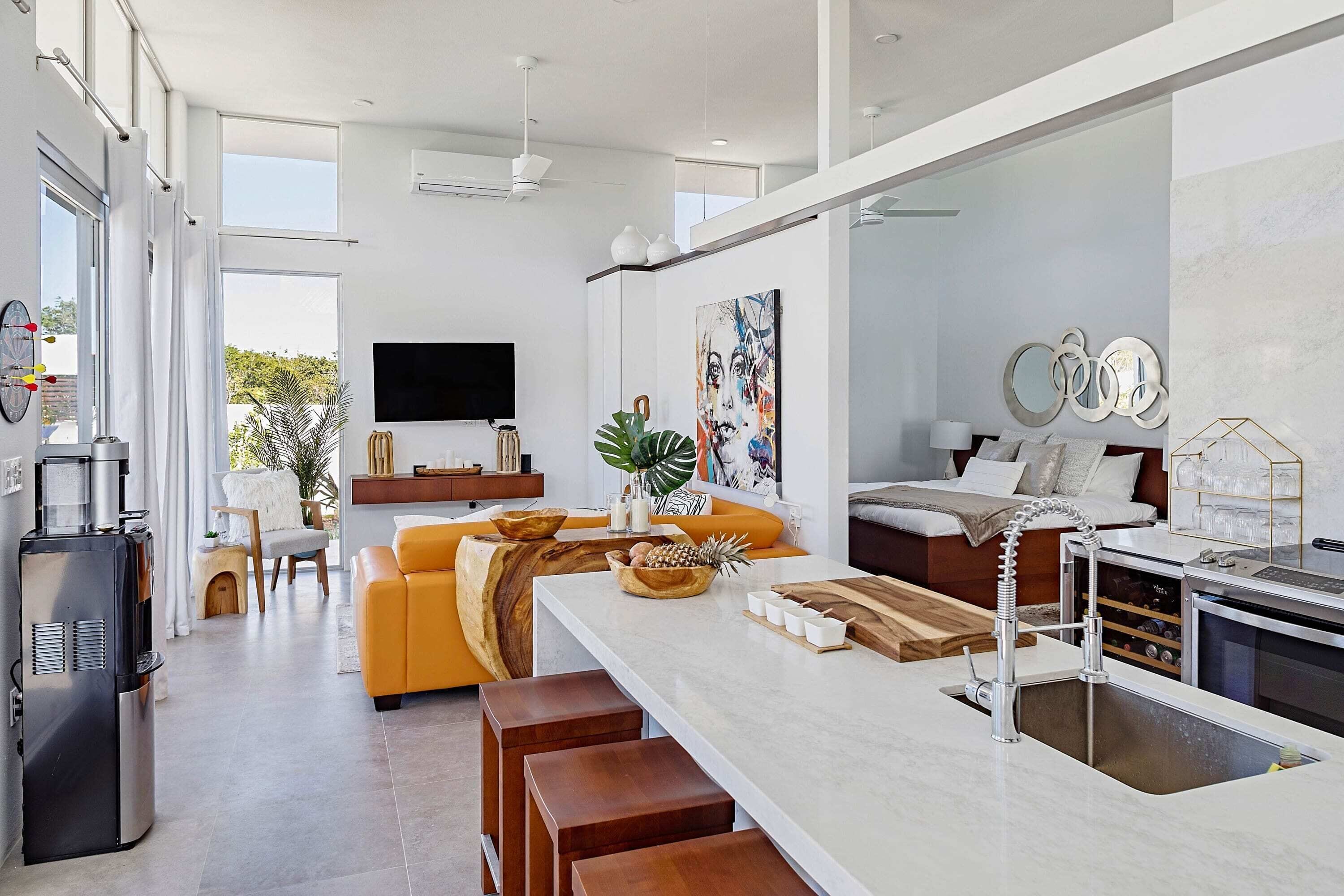A modern kitchen with a central island, a built-in oven, and a large window.