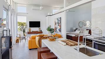 A modern kitchen with a central island, a built-in oven, and a large window.