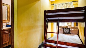 Kerrossänky, jossa on tikkaat, peili ja ikkuna, jossa on verhot.