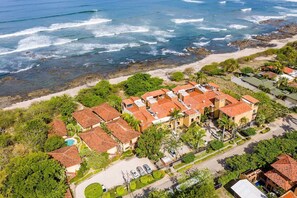 A coastal property with multiple buildings, a swimming pool, and a beach. - Beachfront 2-BR Condo with Saltwater Pool & Sunset Views (Playa Langosta)