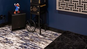 Una stanza con una parete blu scuro, un distributore automatico di popcorn nero e un tavolino con una statuina.