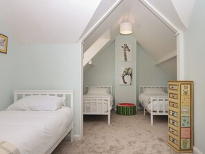 A bedroom with two white beds, a ceiling light, and a wall with animal pictures. - The White House (Okehampton)